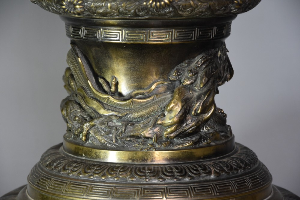 A large 19th-century Japanese Meiji period patinated bronze vase with relief carvings of birds, dragon head handles, and decorative patterned borders. View XI