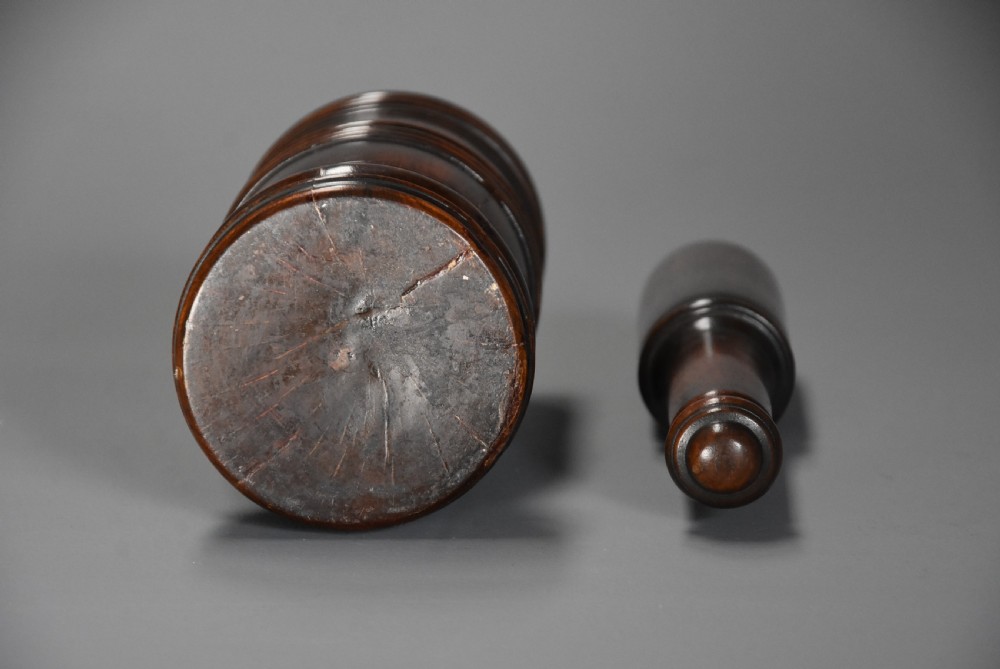A mid-19th century turned walnut pestle and mortar with horizontal moulded bands and a polished brown finish. View IX