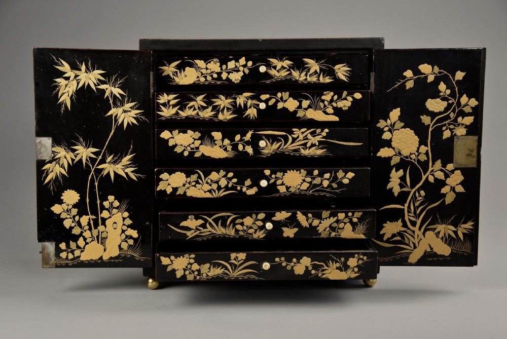 A small rectangular black lacquer table cabinet featuring hand-painted gilt floral and bird decoration with brass bun feet. View XI
