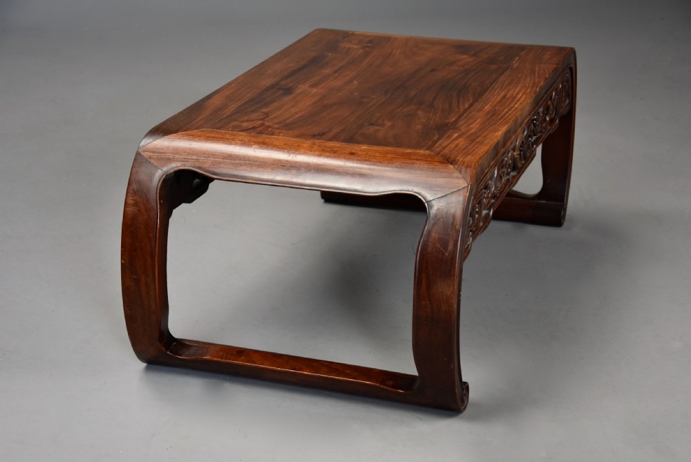 An early 20th-century rectangular Chinese low table crafted from warm brown padouk wood, featuring a carved openwork apron and rounded legs with scroll feet. View VIII