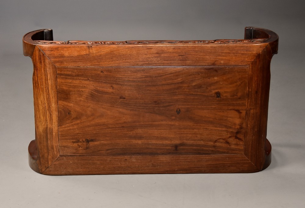 An early 20th-century rectangular Chinese low table crafted from warm brown padouk wood, featuring a carved openwork apron and rounded legs with scroll feet. View XI