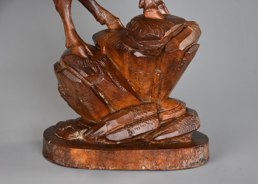 A late nineteenth-century hand-carved linden wood sculpture of a female ibex standing on a rocky naturalistic base. View X