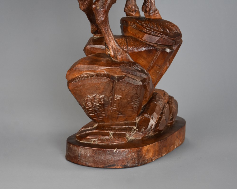 A late nineteenth-century hand-carved linden wood sculpture of a female ibex standing on a rocky naturalistic base. View XII
