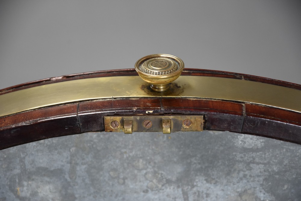 Late eighteenth-century oval mahogany cellarette featuring wide brass binding, side drop handles, and tapered square legs with brass castors. View XIV