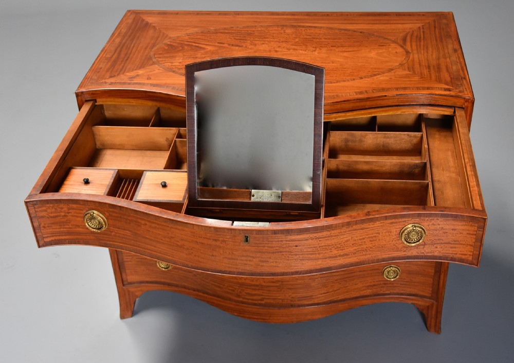 A late eighteenth-century George III serpentine-front satinwood dressing chest featuring four graduated drawers with brass rosette handles. View XI