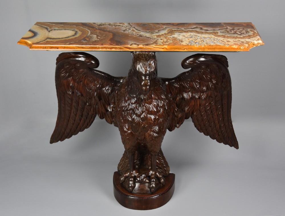 A late 18th-century Baroque carved dark walnut console table featuring a detailed eagle with outstretched wings resting on a rounded base and supporting a polished stone top. View II
