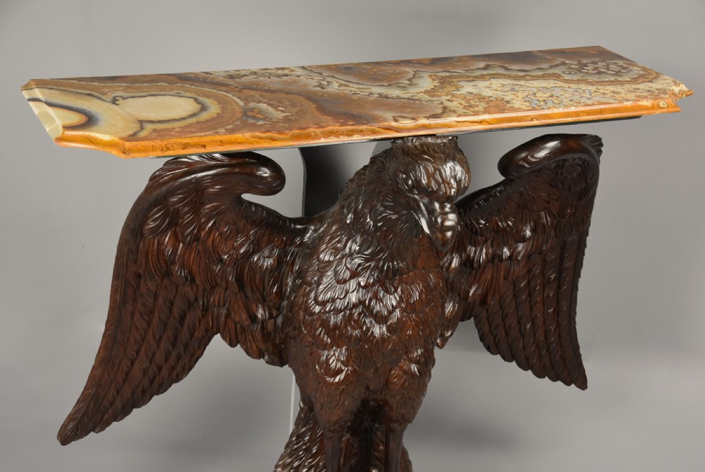 A late 18th-century Baroque carved dark walnut console table featuring a detailed eagle with outstretched wings resting on a rounded base and supporting a polished stone top. View VI
