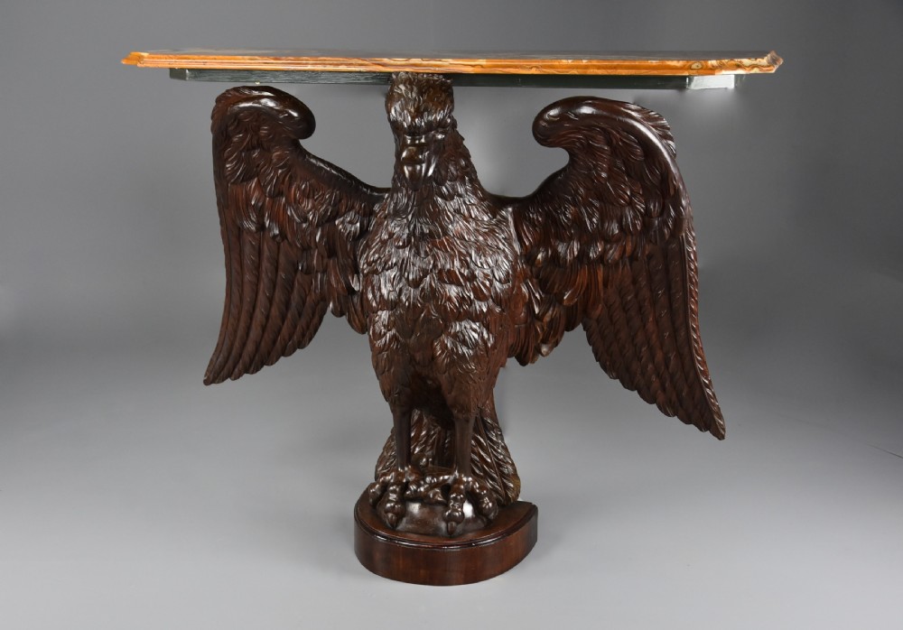 A late 18th-century Baroque carved dark walnut console table featuring a detailed eagle with outstretched wings resting on a rounded base and supporting a polished stone top. View VII