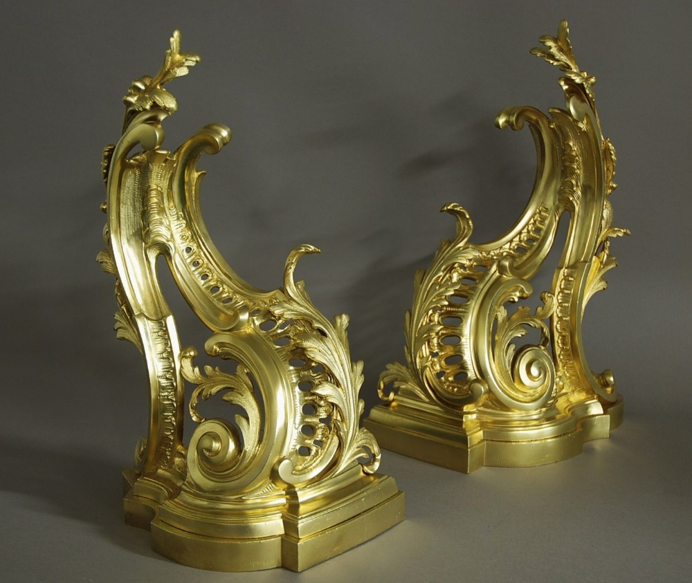 A pair of late nineteenth-century French Rococo style gilt bronze chenets with asymmetric acanthus scrolls and lattice work.