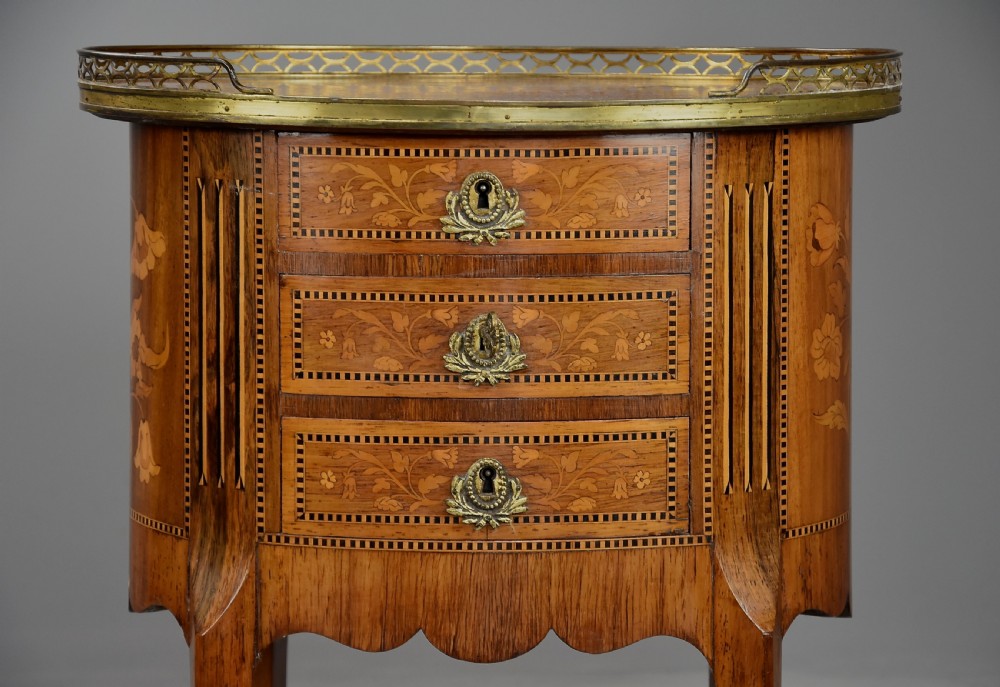 Late nineteenth-century oval French kingwood table en chiffonniere featuring three drawers with floral marquetry, a brass gallery top, slender cabriole legs, and an inlaid lower shelf. View VI