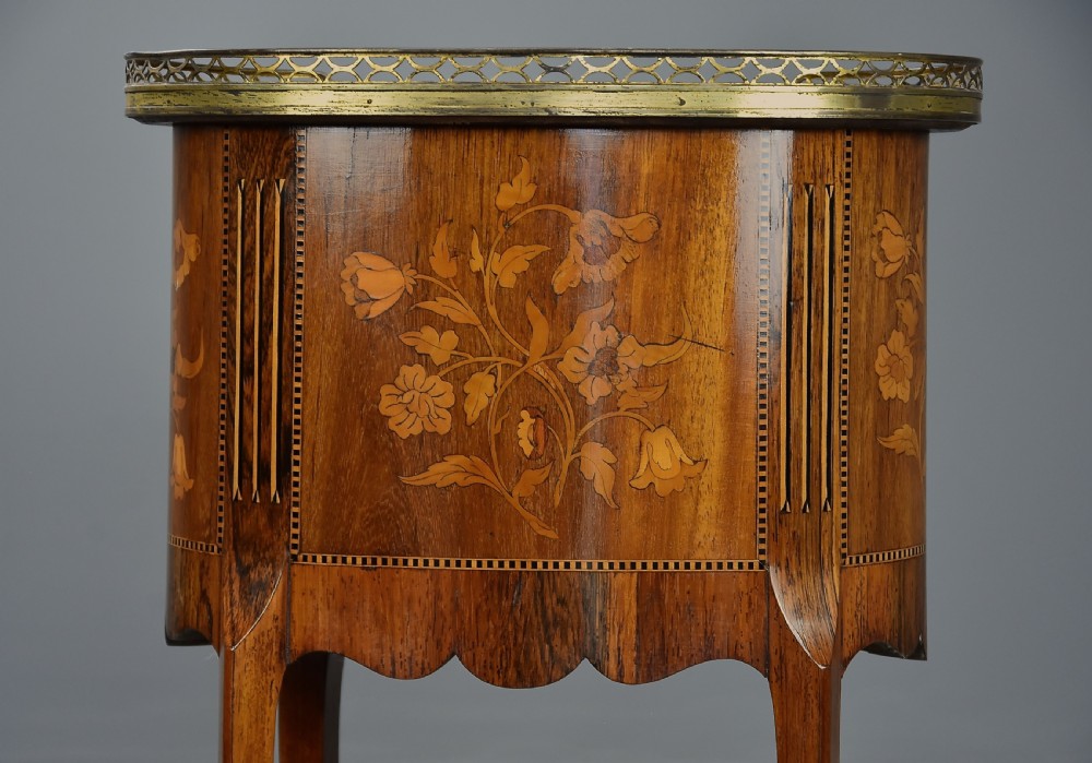 Late nineteenth-century oval French kingwood table en chiffonniere featuring three drawers with floral marquetry, a brass gallery top, slender cabriole legs, and an inlaid lower shelf. View XV