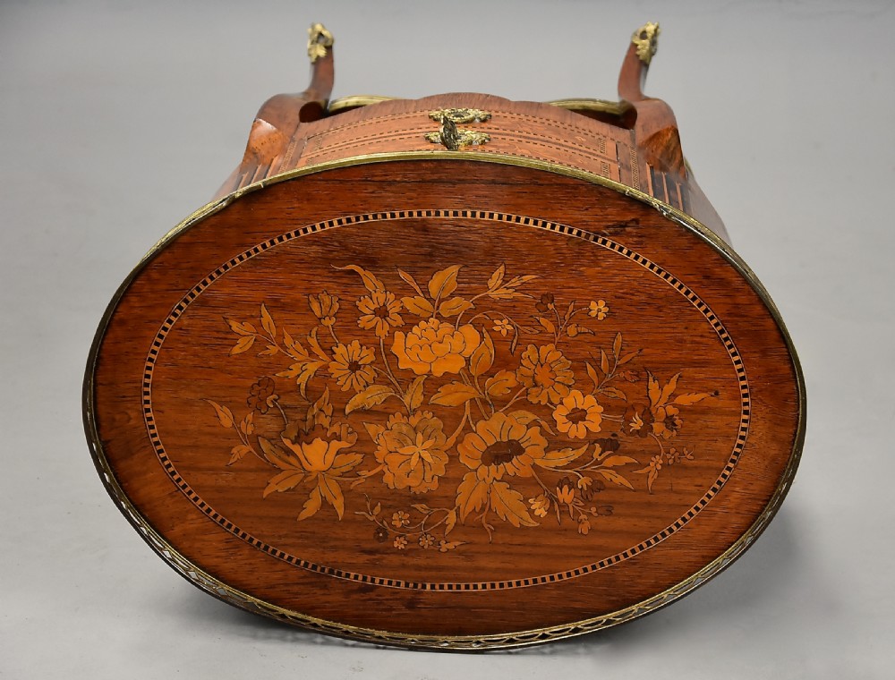 Late nineteenth-century oval French kingwood table en chiffonniere featuring three drawers with floral marquetry, a brass gallery top, slender cabriole legs, and an inlaid lower shelf. View XVII