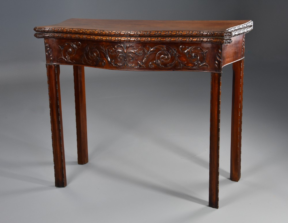 A late 19th-century Chippendale style mahogany card table featuring a serpentine front with carved foliage and square molded legs. View II