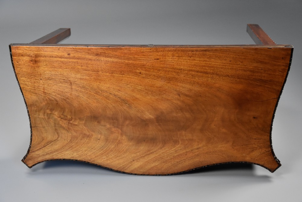 A late 19th-century Chippendale style mahogany card table featuring a serpentine front with carved foliage and square molded legs. View IX