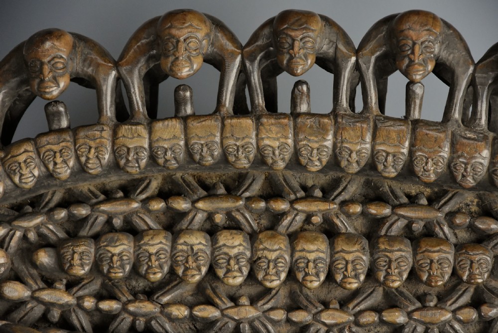 A long hand-carved dark hardwood Bamileke ceremonial bed featuring intricate openwork figurative carvings along the frame and an integrated raised headrest. View XIX