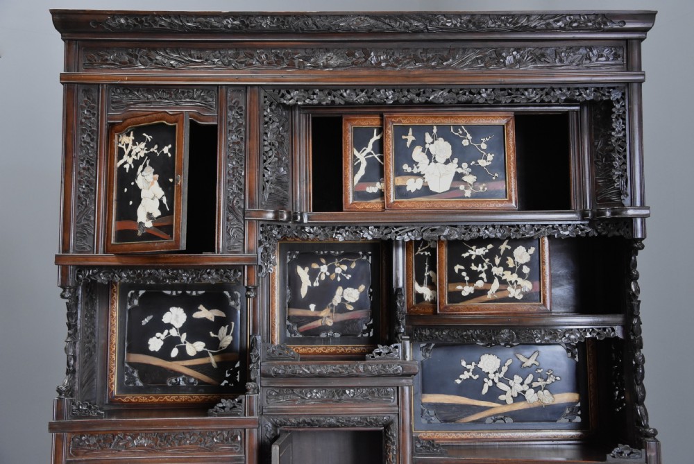 A late nineteenth-century Japanese Meiji period dark brown shodana cabinet featuring asymmetrical open shelves, carved foliage borders, and sliding cupboard doors inlaid with birds and flowers. View VI
