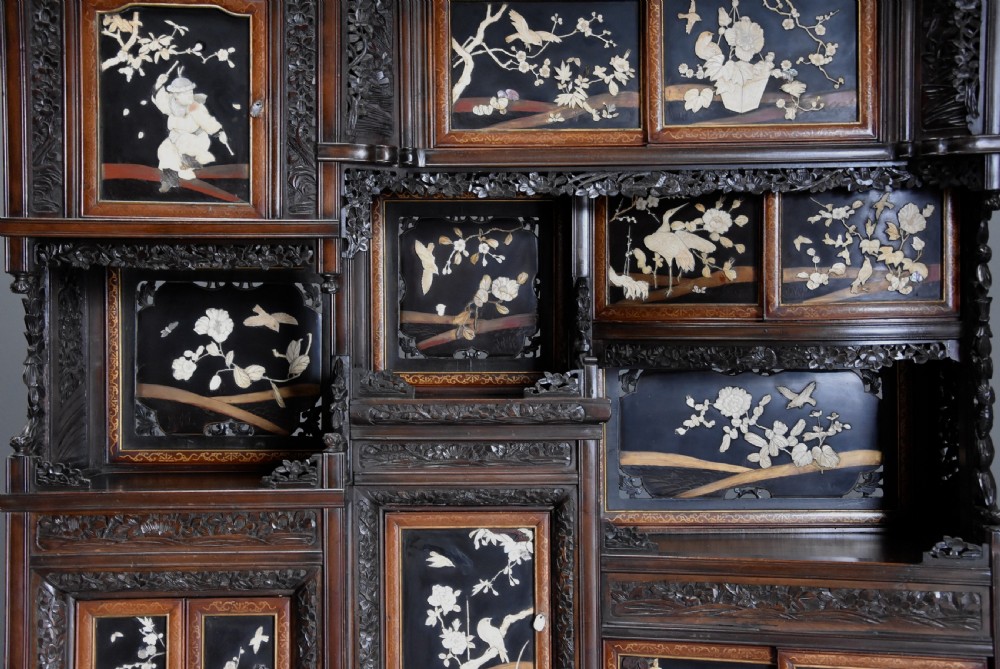 A late nineteenth-century Japanese Meiji period dark brown shodana cabinet featuring asymmetrical open shelves, carved foliage borders, and sliding cupboard doors inlaid with birds and flowers. View VIII
