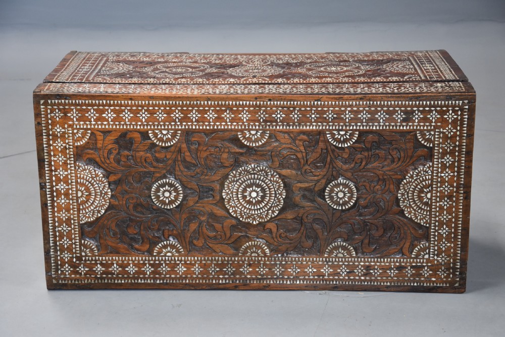 A dark hardwood coffer decorated with detailed geometric mother-of-pearl inlay and relief carvings across the lid and front. View V