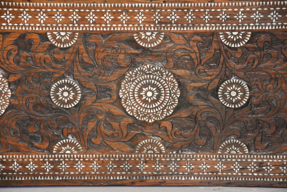 A dark hardwood coffer decorated with detailed geometric mother-of-pearl inlay and relief carvings across the lid and front. View VI