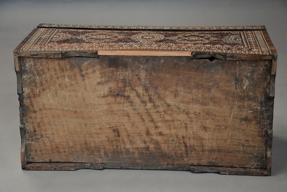 A dark hardwood coffer decorated with detailed geometric mother-of-pearl inlay and relief carvings across the lid and front. View XII