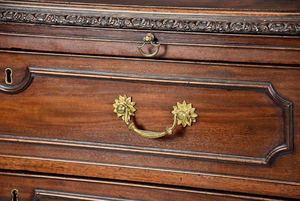 A late 19th-century dark mahogany chest of drawers featuring three graduated drawers, ornate brass swan-neck handles, a pull-out brushing slide, and carved bracket feet. View VII