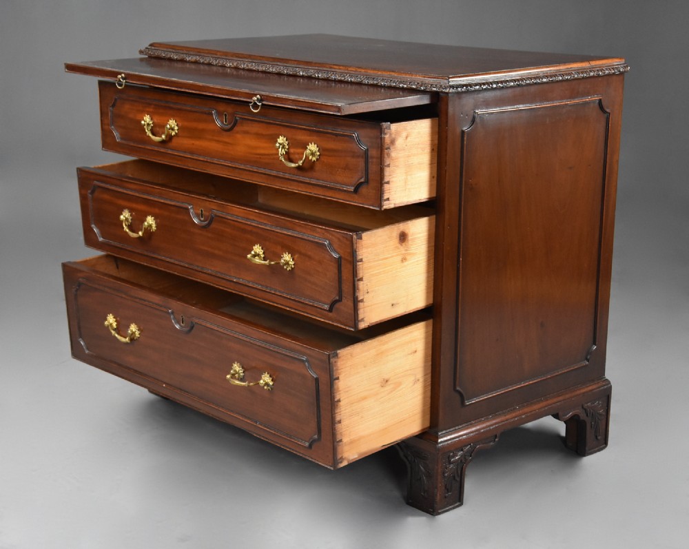 A late 19th-century dark mahogany chest of drawers featuring three graduated drawers, ornate brass swan-neck handles, a pull-out brushing slide, and carved bracket feet. View VIII