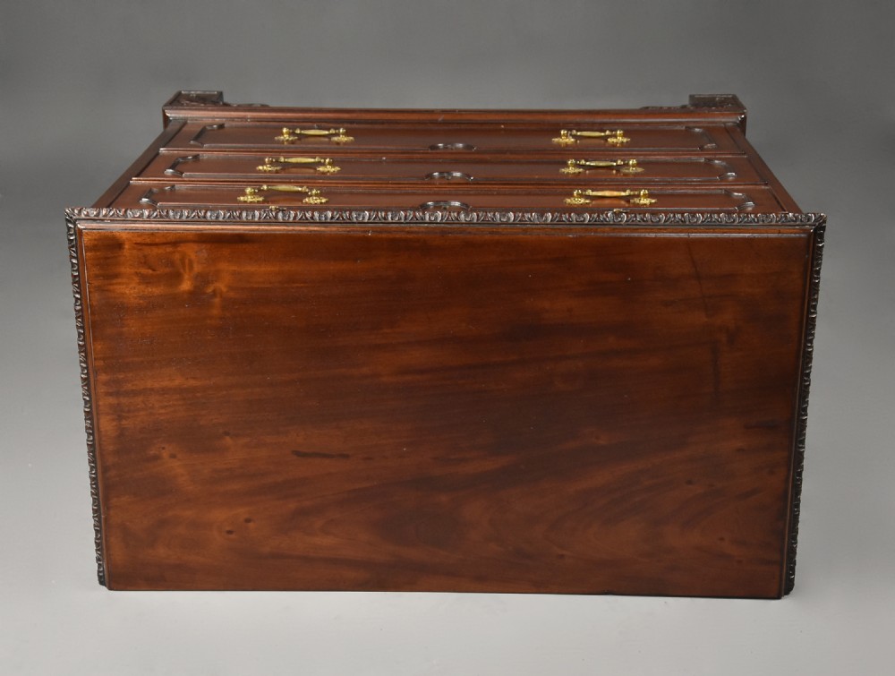 A late 19th-century dark mahogany chest of drawers featuring three graduated drawers, ornate brass swan-neck handles, a pull-out brushing slide, and carved bracket feet. View XII