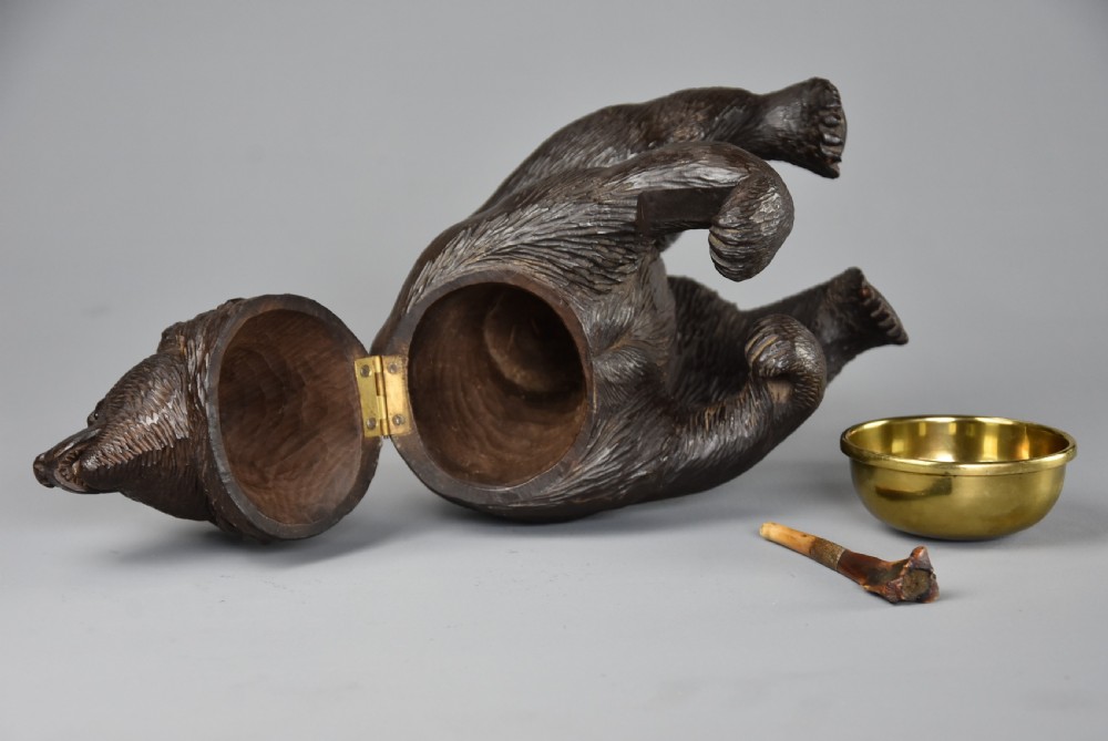 A 19th-century dark brown carved linden wood tobacco box depicting a seated bear holding a pipe beside a brass bowl. View XI