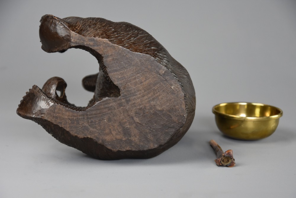A 19th-century dark brown carved linden wood tobacco box depicting a seated bear holding a pipe beside a brass bowl. View XIV