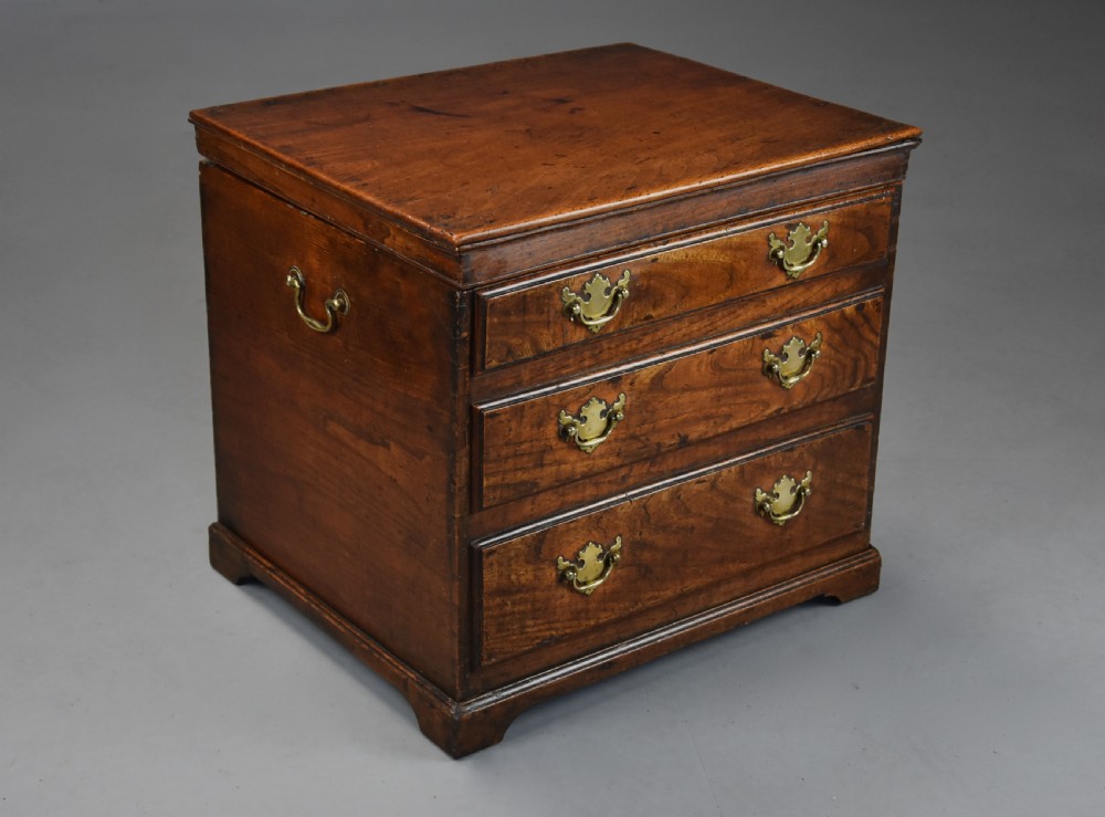 A late eighteenth-century warm brown elm wooden box designed in the form of a miniature chest of drawers with brass handles and bracket feet. View VII