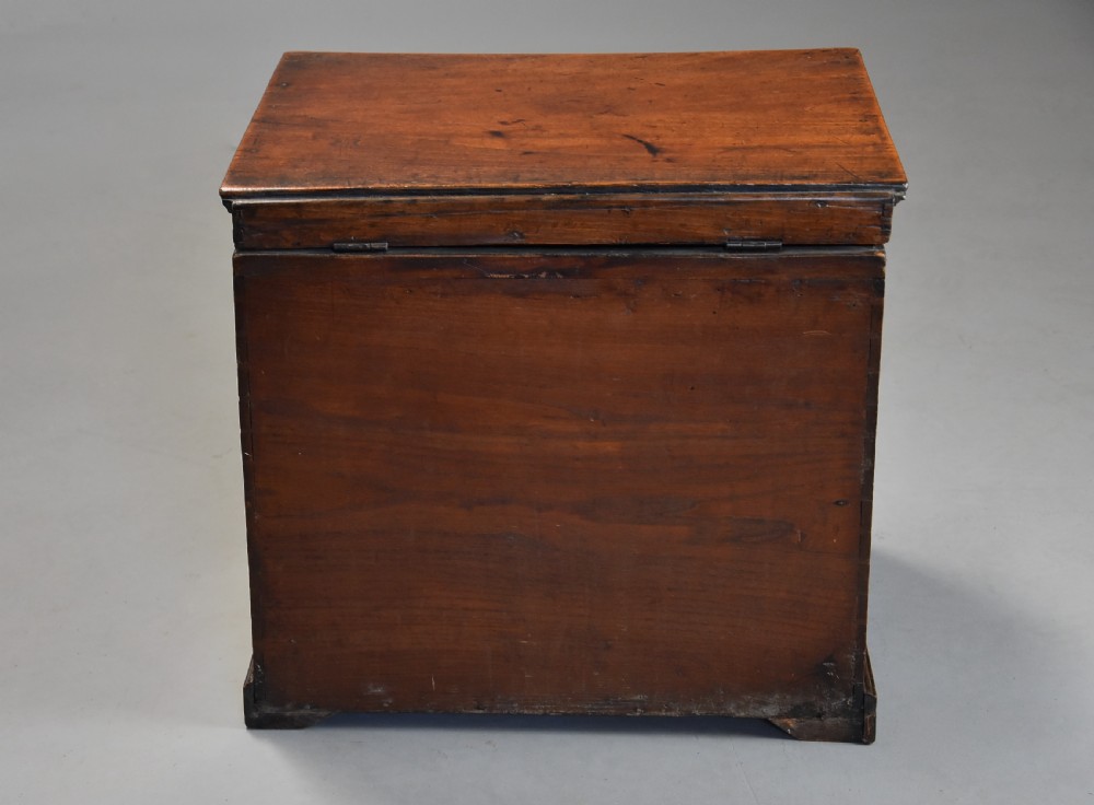 A late eighteenth-century warm brown elm wooden box designed in the form of a miniature chest of drawers with brass handles and bracket feet. View X
