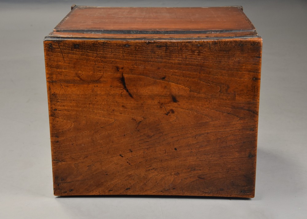 A late eighteenth-century warm brown elm wooden box designed in the form of a miniature chest of drawers with brass handles and bracket feet. View XII