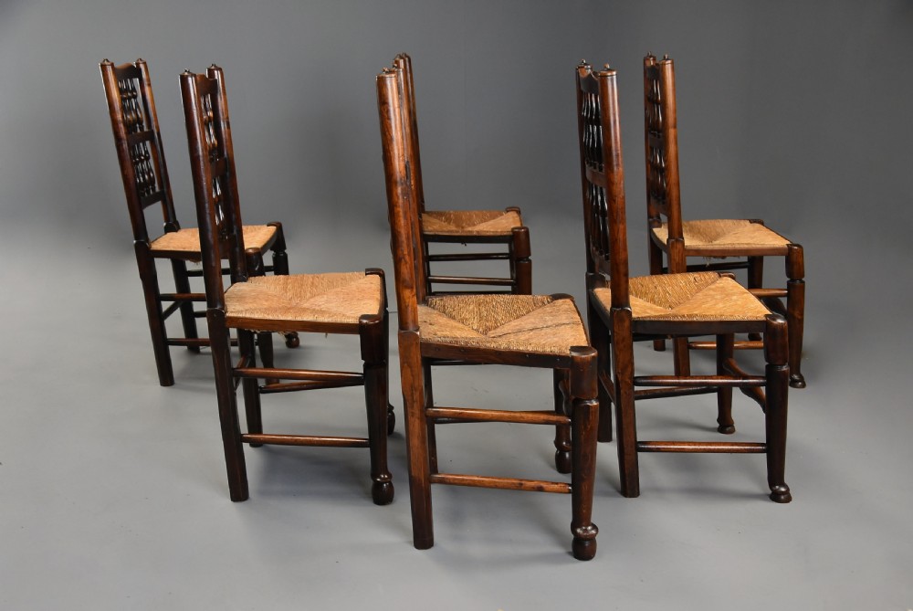 A set of six early nineteenth century ash and elm country dining chairs featuring turned spindle backrests and woven rush seats. View IV