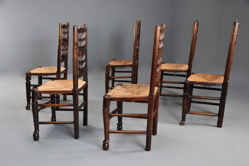 A set of six early nineteenth century ash and elm country dining chairs featuring turned spindle backrests and woven rush seats. View VII