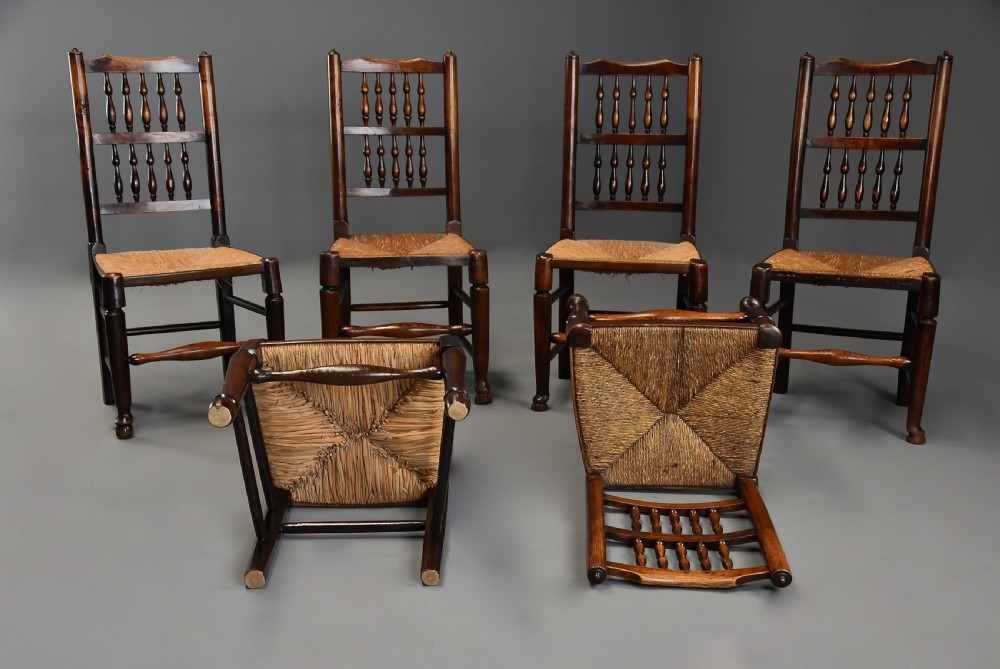 A set of six early nineteenth century ash and elm country dining chairs featuring turned spindle backrests and woven rush seats. View VIII