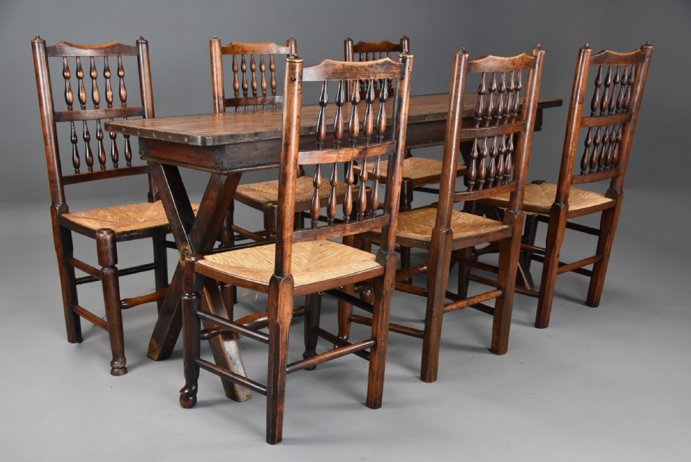 A set of six early nineteenth century ash and elm country dining chairs featuring turned spindle backrests and woven rush seats. View IX