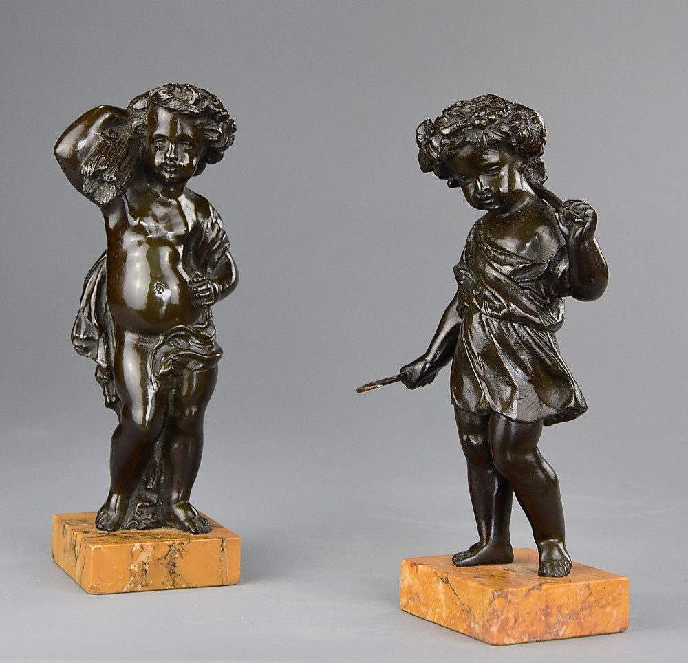 A pair of late 19th-century dark bronze figures depicting harvest putti mounted on rectangular yellow marble bases.