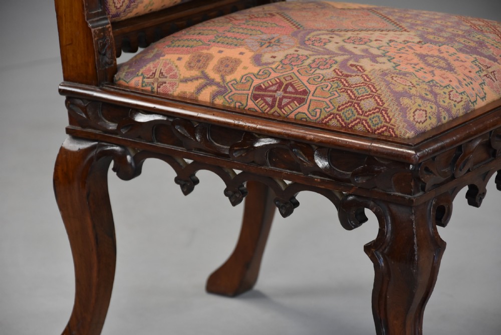 A pair of mid-19th century carved rosewood Gothic Revival hall chairs featuring pointed arch backs, decorative finials, patterned fabric upholstery, and cabriole legs. View XI