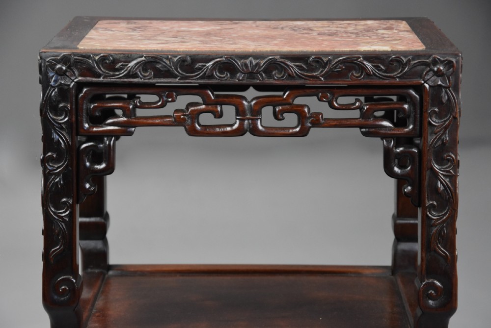 A late 19th-century rectangular Chinese dark hardwood pot stand featuring a pink marble insert top, pierced openwork aprons, and two lower tiers. View VI