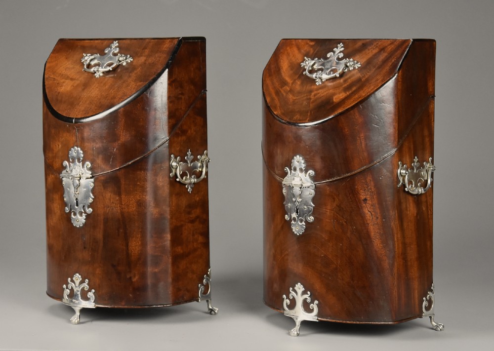 A pair of late eighteenth-century bow-front mahogany cutlery boxes with silver mounts and claw feet.