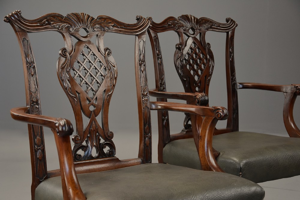 A pair of late nineteenth century mahogany open armchairs featuring carved pierced splat backs and dark green leather upholstered seats. View IV