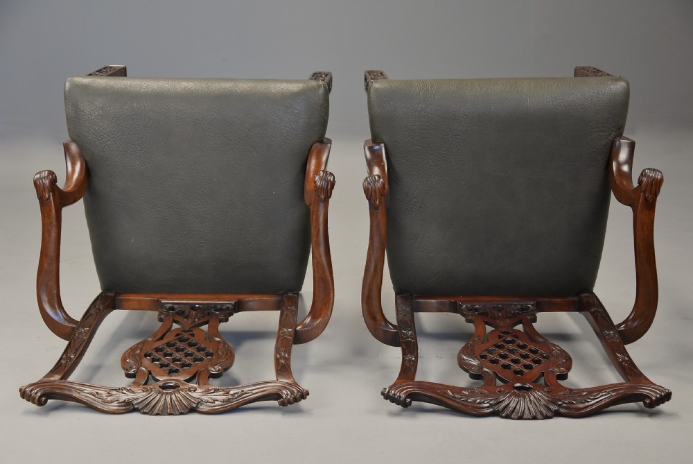 A pair of late nineteenth century mahogany open armchairs featuring carved pierced splat backs and dark green leather upholstered seats. View XII