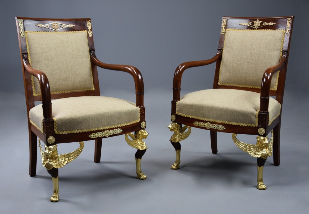 A pair of late 19th-century French mahogany open armchairs featuring gilt-bronze winged lion monopodia legs and beige fabric upholstery. View III