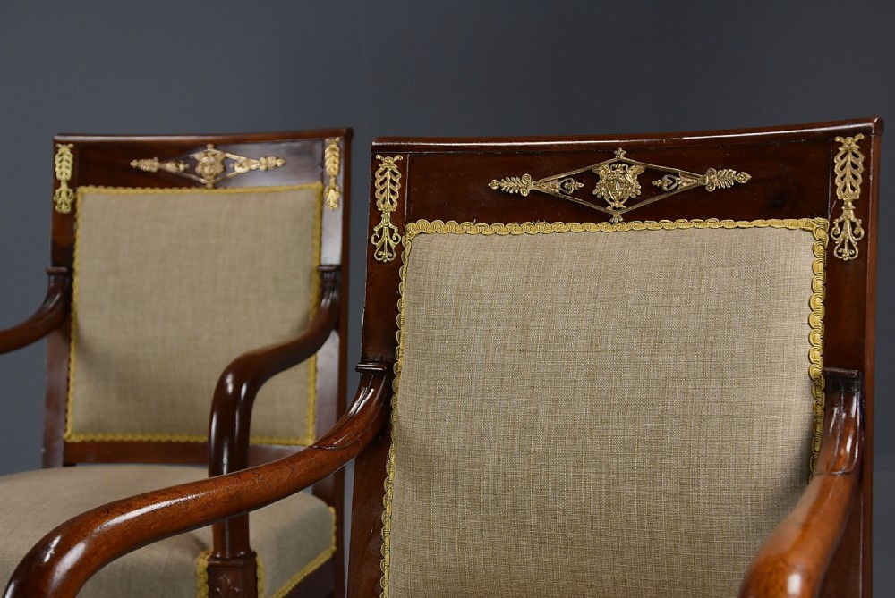 A pair of late 19th-century French mahogany open armchairs featuring gilt-bronze winged lion monopodia legs and beige fabric upholstery. View VII