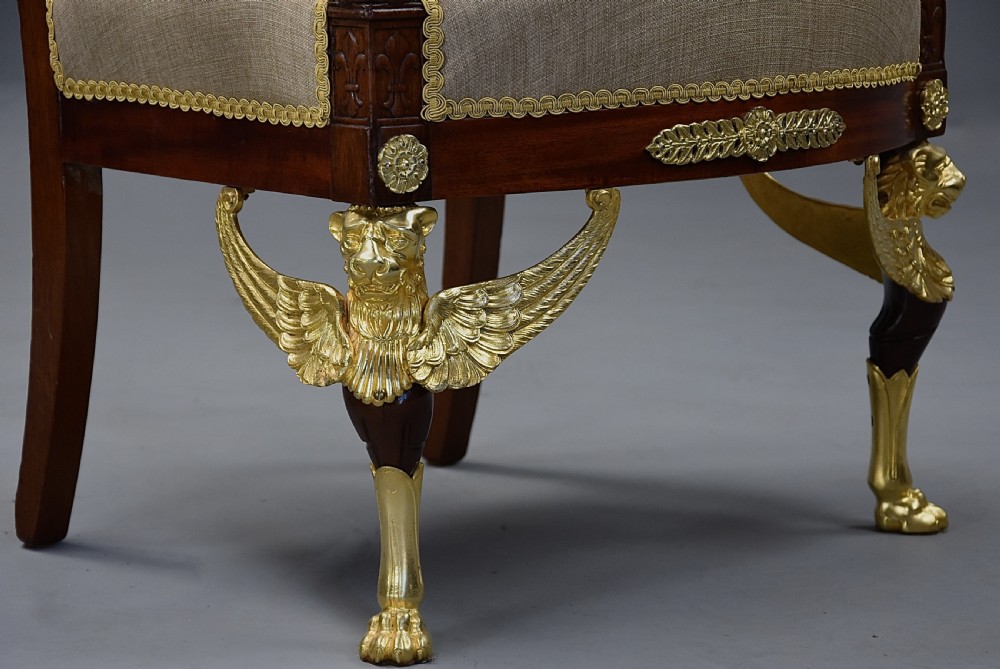 A pair of late 19th-century French mahogany open armchairs featuring gilt-bronze winged lion monopodia legs and beige fabric upholstery. View XI