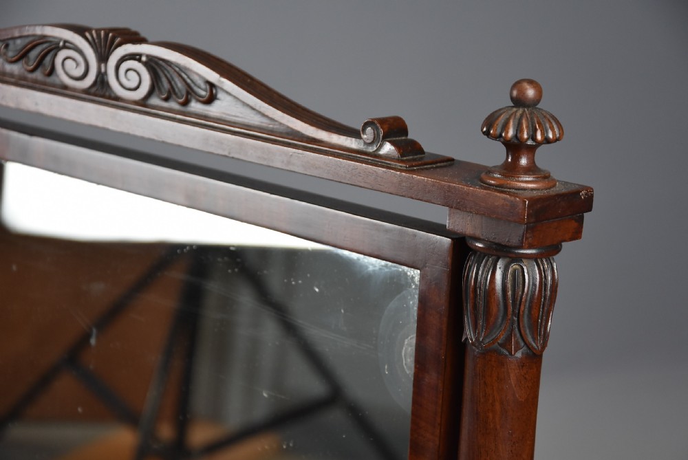 A 19th-century Regency dark mahogany rectangular dressing mirror set between carved column supports on paw feet. View VII