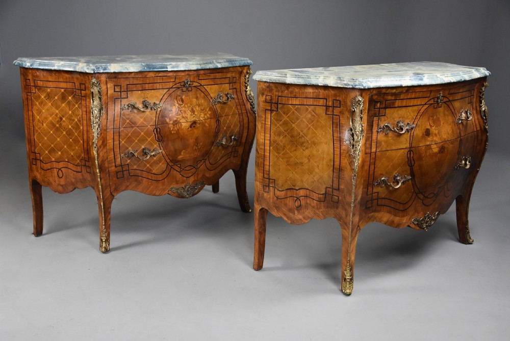 A pair of early 20th century French kingwood bombe commodes with floral marquetry inlay, gilt-bronze mounts, and marble tops. View V