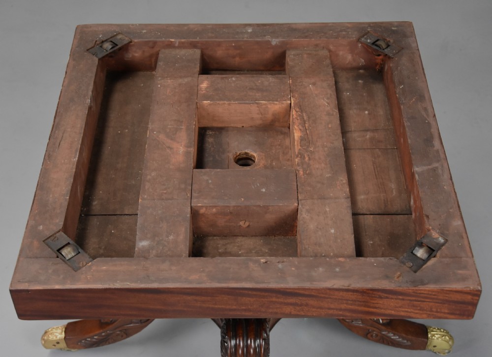 An early 19th-century circular mahogany Regency drum table featuring a dark leather inset top, frieze drawers with line inlay, and a carved central pedestal supported by four scroll legs on brass castors. View XXI