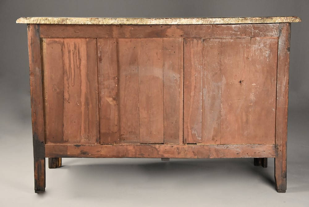 An 18th-century French Regence serpentine commode crafted in rosewood parquetry with gilded ormolu drawer pulls and a contoured marble top. View XVI