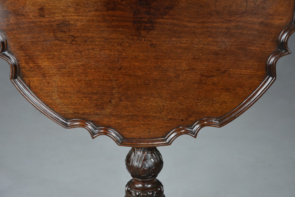An 18th-century George II mahogany tilt-top tripod table featuring a carved piecrust rim, a turned column stem, and cabriole legs. View VIII